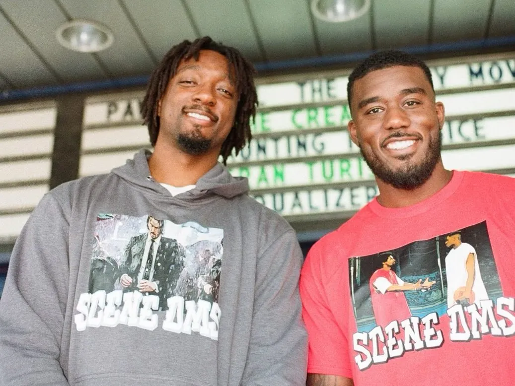 MiKyle McIntosh and Duane Notice in SceneDMs shirts, smiling under a cinema marquee
